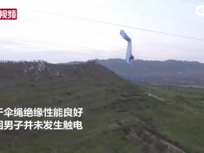 河北张家口：男子玩滑翔伞挂在220千伏高压线上