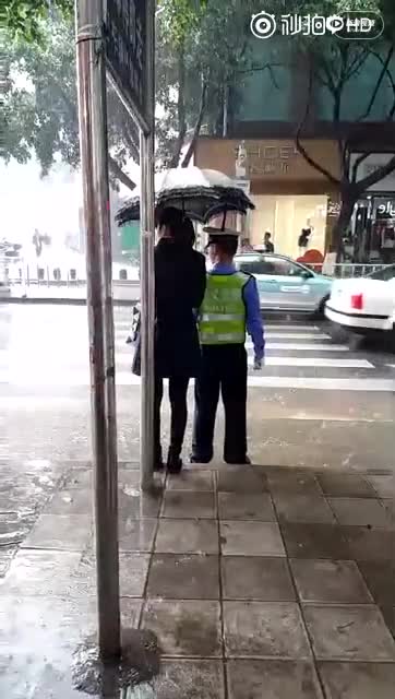 身边的感动：贵州兴义一女孩大雨中为交警打伞
